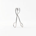 Stainless steel eyelash curler on white background