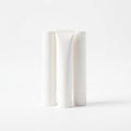 Three white lip balm tubes standing in a row