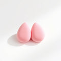 Two pink makeup blending sponges on white background